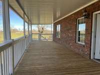 Main level covered back porch with views of acreage and fenced back yard