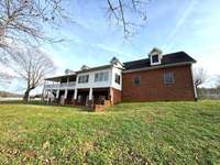 View of back of home from fenced yard