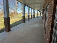 Lower level covered porch that opens to fenced backyard