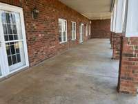 Lower level covered porch that opens to fenced backyard