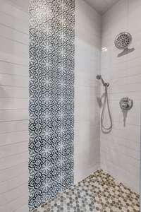 Large walk in shower with designer tiles.