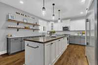 Large kitchen and island is the epitome of both function and style.  Plenty of room to move around and have several cooks in the kitchen with this ample counter space .