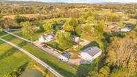 Aerial view of the home, large out building and fenced back yard.