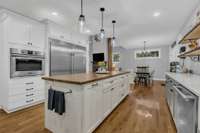 Built in oven next to commercial grade refrigerator/freezer.