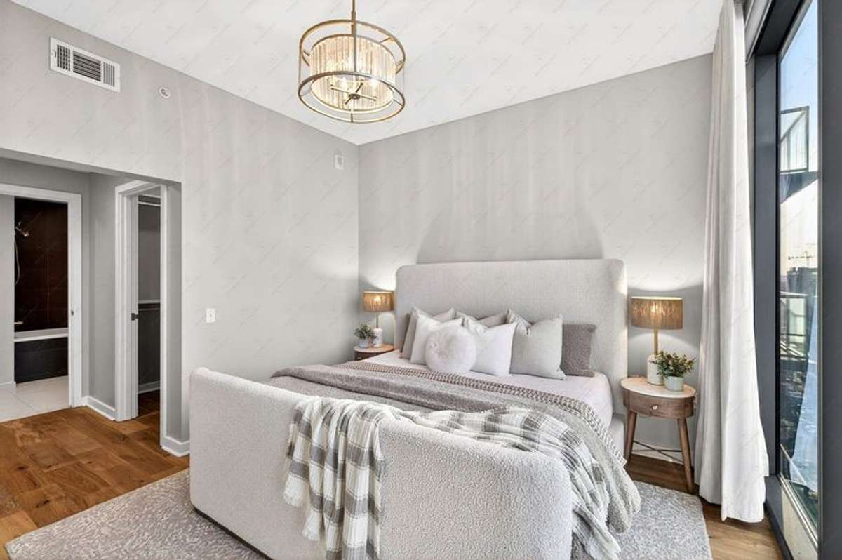 True bedroom suite with dual closets off hall into the primary bathroom