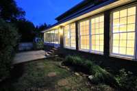 Glow from inside lights enhances night time backyard ambiance.