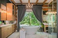Renovated Primary Bath with dual vanities, soaking tub enjoying gorgeous and private view of the forest that surrounds the property