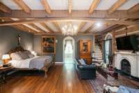 Primary bedroom with a view into the bathroom suite, sitting area with a fireplace