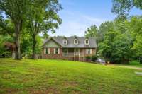 Large front yard with mature trees.