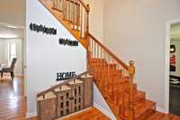 Entry foyer leading to the living room, kitchen, office and to the second floor.