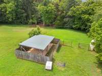 Lean-to in rear of property for storage leading into another fenced area.