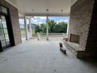 Covered outdoor living featuring a 42” wood-burning fireplace and a connected grilling porch Photo taken 6/22/25