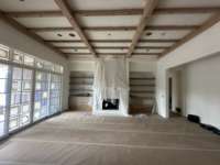 Great Room with a a coffered ceiling, wood-burning fireplace and built-in custom cabinetry to either side.  Photo taken 7/2/25