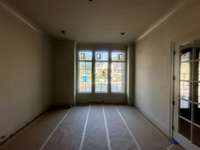 Study on the main level showcasing decorative glass doors and triple windows with a walk-in storage closet. Photo taken 7/2/25