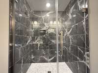 Luxurious extra large modern shower floor to ceiling glass.