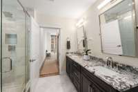 The primary bath has been fully renovated with heated tile floors, new vanity, countertops, plumbing, mirrors, lighting and stunning shower.