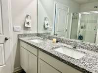 Upstairs Bathroom with double vanities with granite tops; 2 closets and fiberglass shower