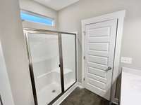 Owner's suite large shower with easy clean surface and Luxury vinyl tile flooring