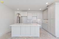 Kitchen area with white cabinets and granite countertops.  Tile backsplash to be installed soon.