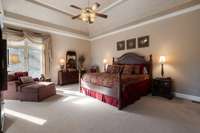 Large Main Floor Primary Bedroom with try ceiling and room for a Sitting Area.