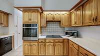 Gorgeous wood cabinets surround the cooktop range.