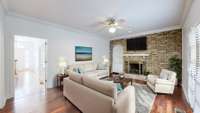 Den captured in a professionally staged photo. Notice the impressive fireplace with a brick accent wall. (Stage photo)