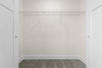A generous walk-in closet with built-in shelving. Your wardrobe just found its perfect home.
