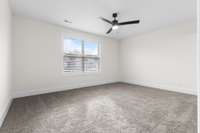 Cozy and comfortable primary bedroom with plush carpeting and an attached en suite for your convenience.