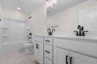 Crisp and clean full bathroom with a timeless design and matte black fixtures for a modern touch.