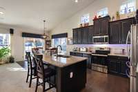Large, open kitchen with granite island, stainless steel appliances and tons of cabinets.