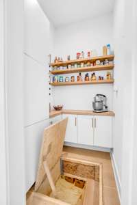 Behind a flush panel in the pantry floor, is a concealed entry leads to the storm shelter