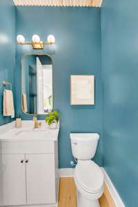 A sleek half bath with designer finishes and a wood-paneled ceiling that adds warmth, texture, and charm.