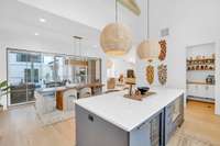 With a direct line from the kitchen to the dining space and out through four-panel French doors, this layout was built for hosting and gathering year-round.
