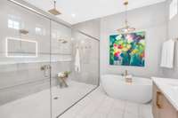 A beautifully tiled 10' x 5' shower with dual shower heads, a rainfall fixture, and a sleek shaving ledge—where luxury meets everyday ease.