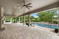 Private covered patio features stained beadboard ceiling with fans and recessed lighting.