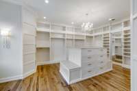 Spacious custom Owners Suite closet with built-ins, drawers, & various hanging space options. So hard to capture how large this is with a camera. You must see in person. There is also a very large unfinished space behind the hanging option wall.