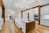Gorgeous coffered ceiling with hanging globes over the island.