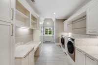 Large multi-purpose laundry room that offers elevated Samsung washer/dryer, a built-in drop zone, writing and/or computer desk, undermount large sink plus walk-in storage/pantry closet.