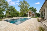 A view of the outdoor space from the entrance gate. The elegant pool stone wall becomes a fire wall at night....you must schedule a night showing to see this space come alive!