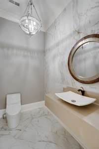Elegant Powder Room off entry hall with designer plumbing fixtures and globe lighting