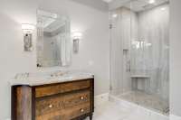 The custom curved-edge dual walnut vanities with marble tops are both elegant and so chic.  Another view of one of the "His and Her" oversized marble showers with custom glass door and linear drains.