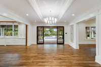The breakfast room opens to the den and kitchen. Great for entertaining, the large steel doors open to the outdoor covered porch and pool.