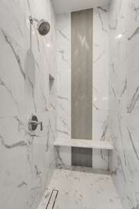 Large marble and tile shower with decorative gray and white herringbone pattern. Really stunning in person!