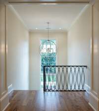 Modern and chic iron design on the hand-forged iron stairwell welcomes you to the upper level of this home. The floor to ceiling window is a stunner and the large globe chandelier is motorized for easy cleansing.