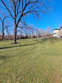 Back yard of home from the driveway side!  Note: Covered deck with Sun Setter shades, lights, etc.