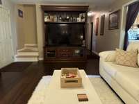 View from fireplace steps to upstairs - hallway to basement, main level bedrooms including primary bedroom, guest bedroom and both baths.