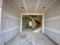 Dramatic entry foyer featuring a curved staircase off of the covered front porch Photo taken 629/25