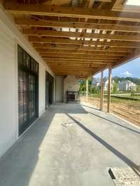Covered outdoor living featuring a 42" wood-burning, plus an adjoining grilling porch. Photo taken 6/26/25