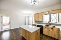 Kitchen complete with stone countertops, basin sink, plenty of cabinet and counter space and informal dining space