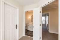View from Primary of walk-in closet door, primary bathroom and hallway